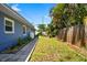 Lush backyard with plants and brick-lined walkway, complemented by the blue home exterior at 7230 17Th N Ln, St Petersburg, FL 33702