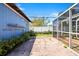 Brick-paved backyard area with a screen lanai in view and mature landscaping at 7230 17Th N Ln, St Petersburg, FL 33702