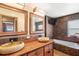 Bathroom with stone vessel sinks, wooden cabinets, brown tile and a large tub at 7230 17Th N Ln, St Petersburg, FL 33702