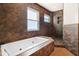 Bathroom featuring a large bathtub, shower, and brown tile walls and flooring at 7230 17Th N Ln, St Petersburg, FL 33702