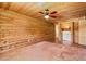 Spacious bedroom with wooden plank walls, ceiling fan, tile flooring, and closet laundry area at 7230 17Th N Ln, St Petersburg, FL 33702