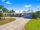 The home boasts a long circular driveway with mature landscaping, leading to a well-maintained blue house at 7230 17Th N Ln, St Petersburg, FL 33702
