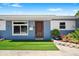 Charming blue house featuring a manicured lawn, with an inviting front door and beautiful landscaping at 7230 17Th N Ln, St Petersburg, FL 33702