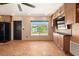 A tiled living room includes a black refrigerator and cabinet storage next to a window to the outside at 7230 17Th N Ln, St Petersburg, FL 33702