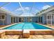 The bright enclosed pool area with tiled deck, and views of the home's rear and side yards at 7230 17Th N Ln, St Petersburg, FL 33702