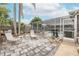Backyard patio and seating area with a pool, palms, and screen enclosure at 7341 Bimini Dr, Port Richey, FL 34668
