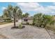 Well-maintained home with a gravel front yard, mature palm trees, and charming curb appeal at 7341 Bimini Dr, Port Richey, FL 34668