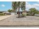 Home exterior featuring a well-kept gravel yard, palm trees, and solar panels at 7341 Bimini Dr, Port Richey, FL 34668