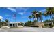 The community's entrance features lush tropical landscaping, a guard house, and a view of the condominiums at 8211 Brent St # 837, Port Richey, FL 34668