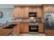 Updated kitchen with stainless steel appliances, wood cabinets, and stone countertops at 8211 Brent St # 837, Port Richey, FL 34668