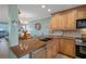 Well-appointed kitchen with wood cabinetry, stainless steel appliances, and adjacent dining area at 8211 Brent St # 837, Port Richey, FL 34668