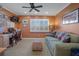 Comfortable living room with a sofa, ceiling fan, shutters, and view of a desk area at 8211 Brent St # 837, Port Richey, FL 34668