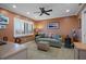 Cozy living room with a comfortable sofa, ceiling fan, and natural light from shuttered windows at 8211 Brent St # 837, Port Richey, FL 34668