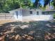 Rear exterior view with freshly painted white stucco and fenced-in backyard at 825 Lincoln Ave, Tarpon Springs, FL 34689