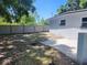 View of the property's backyard with a concrete patio and tall wooden fence at 825 Lincoln Ave, Tarpon Springs, FL 34689
