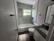 Modern bathroom with a tub and shower, new vanity, sleek fixtures, and stylish tile at 825 Lincoln Ave, Tarpon Springs, FL 34689