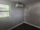 A bright bedroom featuring wood-look floors and a mini-split AC at 825 Lincoln Ave, Tarpon Springs, FL 34689