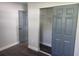 Bedroom features wood-look floors, an open closet, and a gray painted door at 825 Lincoln Ave, Tarpon Springs, FL 34689