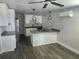 Open kitchen featuring grey countertops, an island cooktop, stainless steel appliances and modern light fixtures at 825 Lincoln Ave, Tarpon Springs, FL 34689