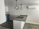 Open kitchen featuring grey countertops, an island cooktop, and modern hanging light fixtures at 825 Lincoln Ave, Tarpon Springs, FL 34689