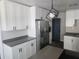 Modern kitchen with white cabinets, stainless steel appliances, gray countertops, and contemporary lighting at 825 Lincoln Ave, Tarpon Springs, FL 34689
