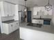 Modern kitchen with white cabinets, stainless steel appliances, gray countertops, and contemporary lighting at 825 Lincoln Ave, Tarpon Springs, FL 34689
