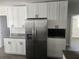 Bright kitchen features stainless steel fridge and white cabinets with modern hardware at 825 Lincoln Ave, Tarpon Springs, FL 34689