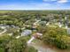 Aerial perspective of the property highlighting its setting amid mature trees and landscaping at 8466 Eldridge Rd, Spring Hill, FL 34608