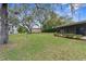 Large backyard with mature trees and a storage shed at 8466 Eldridge Rd, Spring Hill, FL 34608