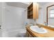 Bathroom with wood cabinets, combination tub and shower, and built in shelves at 8466 Eldridge Rd, Spring Hill, FL 34608