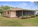 Side view of property shows enclosed patio and spacious backyard at 8466 Eldridge Rd, Spring Hill, FL 34608