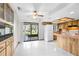Open kitchen area with wooden cabinets, white appliances, and sliding glass doors to the backyard at 8466 Eldridge Rd, Spring Hill, FL 34608