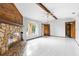 Bright living room featuring a stone fireplace, tile flooring, and a beamed ceiling at 8466 Eldridge Rd, Spring Hill, FL 34608