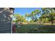 Sideyard view of a gray home with a patio, green lawn, and beautiful trees, perfect for enjoying outdoor living at 9625 Pat St, Hudson, FL 34669