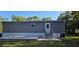 View of the backyard, showing the vinyl siding, small deck, and a door with steps at 9625 Pat St, Hudson, FL 34669