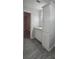 The bathroom features a single sink vanity with storage and gray wood flooring at 9625 Pat St, Hudson, FL 34669