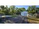 Spacious property featuring a detached one-car garage accessible via a paved driveway, complemented by a green lawn at 9625 Pat St, Hudson, FL 34669