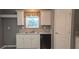 Functional kitchen area featuring white cabinetry and countertops, along with modern appliances at 9625 Pat St, Hudson, FL 34669