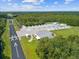 Aerial view of a landing strip, several storage units, and a maintenance building, all surrounded by lush green trees at 10318 Piper Dr, New Port Richey, FL 34654