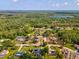 An aerial view displays the property's position near a serene lake surrounded by lush forestry at 10318 Piper Dr, New Port Richey, FL 34654