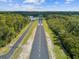 A high aerial view of the landing strip, a roadway, and lush, green trees at 10318 Piper Dr, New Port Richey, FL 34654