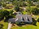 A beautiful aerial view shows a home with a pool, shed, and fenced yard backing up to a wooded area at 10318 Piper Dr, New Port Richey, FL 34654