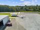 Overhead view of the airport with a small plane parked near the hangar and runway at 10318 Piper Dr, New Port Richey, FL 34654