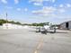 Pristine airfield view of a twin-engine airplane parked in front of a hanger at 10318 Piper Dr, New Port Richey, FL 34654