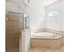 Bathroom featuring walk-in shower and a separate garden tub, plus a window for natural light at 10318 Piper Dr, New Port Richey, FL 34654