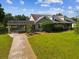 A gray home features well-manicured lawns, mature plants, and a convenient carport at 10318 Piper Dr, New Port Richey, FL 34654
