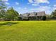 Charming two-story home has lush green lawn and manicured landscaping with mature trees and shrubbery at 10318 Piper Dr, New Port Richey, FL 34654