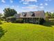 Charming two-story home boasts a lush green lawn and mature landscaping with multiple dormer windows at 10318 Piper Dr, New Port Richey, FL 34654