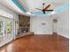 Bright living room boasts a stone fireplace, ceiling fan, and access to the outdoors at 10318 Piper Dr, New Port Richey, FL 34654