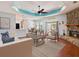 Inviting living room featuring a stone fireplace, tray ceiling, and neutral decor, offering a cozy and stylish space at 10318 Piper Dr, New Port Richey, FL 34654